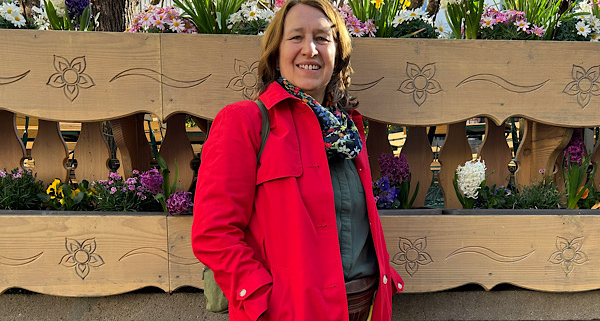 Anita Griebl steht vor Blumen und lächelt – ein Bild für Lebensfreude, Wärme und innere Verbundenheit.