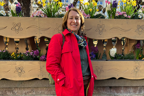 Lebensfreude verloren_ Anita Griebl steht vor Blumen und lächelt – ein Bild für Lebensfreude, Wärme und innere Verbundenheit.