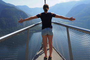 Junge Frau mit Hut auf einem Steg über dem Meer, den Blick zum Horizont gerichtet – Symbol für Aufbruch, Freiheit und innere Klarheit.
