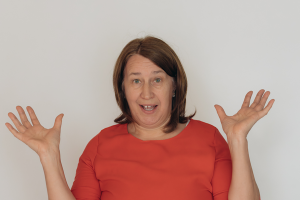 Erklärende Geste, verdutzter Blick – Anita Griebl, Heilenergetikerin im Moment der Erkenntnis: Was einst selbstverständlich war, darf jetzt gehen. Raum für Neues entsteht.