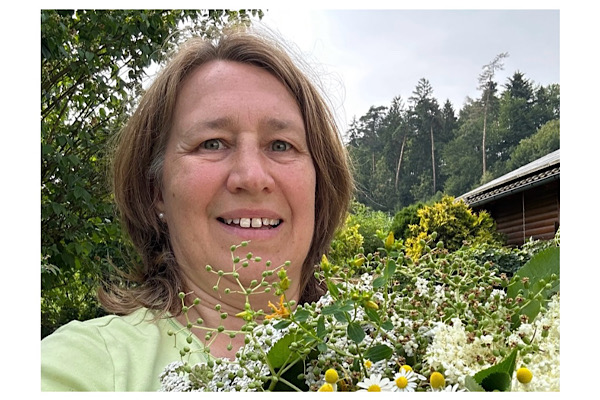 Anita Griebl mit einem Strauß frischer Kräuter – Porträtfoto für ihre persönliche Kräuterreise.