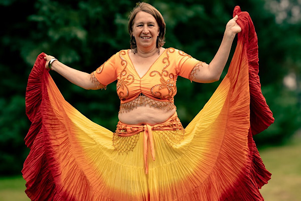 Anita Griebl entfaltet ihren farbigen Rock wie Flügel – ein kraftvolles Symbol für Selbstliebe, Transformation und gelebte Weiblichkeit.