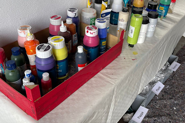 Vielfarbige Acrylfarben in einer Box, Symbol für kreative Entfaltung beim 2. Energie-Mal-Seminar.