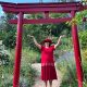 m Nepal-Park unter dem roten Tor erhebt sich die Energie – Anita Griebl in einem Moment der spirituellen Öffnung und bewussten Präsenz.