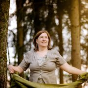 Anita Griebl steht im Wald mit fließendem Kleid und Tuch in den Händen – ein Moment der Intuition, Naturverbundenheit und inneren Klarheit.