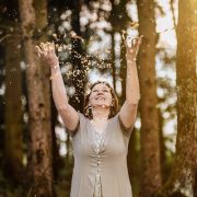 Anita Griebl im Wald, umgeben von Goldflitter – visuelle Metapher für Licht, Energiearbeit und den Start in die Heilenergetik