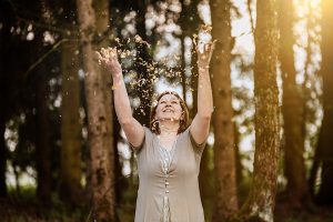 Anita Griebl im Wald, umgeben von Goldflitter – visuelle Metapher für Licht, Energiearbeit und den Start in die Heilenergetik