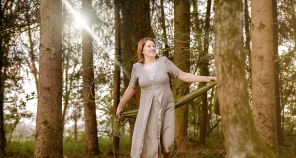 Anita Griebl barfuß im Wald, von Licht durchflutet – Moment der Selbstverbundenheit, Bewegung und heilenergetischer Präsenz.