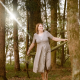 Anita Griebl barfuß im Wald, von Licht durchflutet – Moment der Selbstverbundenheit, Bewegung und heilenergetischer Präsenz.