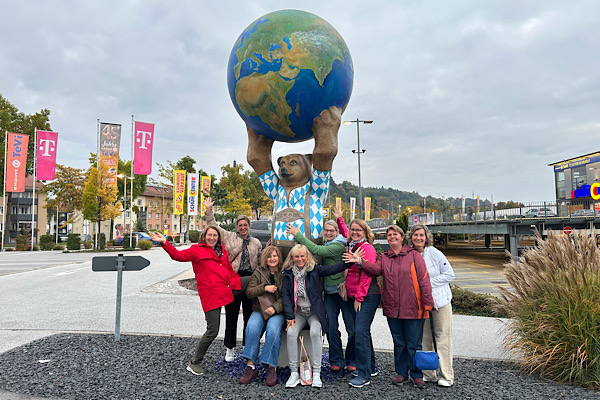 Anita Griebl mit Seminarteilnehmerinnen vor der Bärenfigur mit Weltkugel in Deggendorf – ein Moment voller Kraft, Verbindung und gelebter Präsenz.