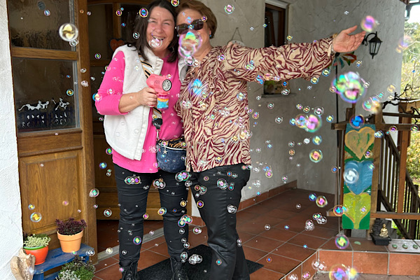Heidi und Geburtstagskind Gisela in einem Moment voller Leichtigkeit – umhüllt von schimmernden Seifenblasen.