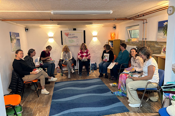 Seminarteilnehmerinnen sitzen gemeinsam im Kreis im Seminarraum – ein sichtbarer Ausdruck von Vertrauen, Sicherheit und authentischer Begegnung.