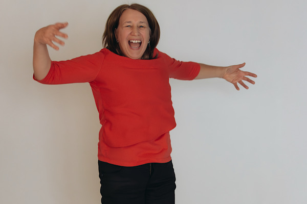 Anita Griebl springt lachend in die Luft und zeigt sichtbare Lebensfreude.