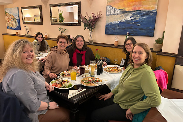 Wir Partnerinnen sitzen in einer Pizzeria zusammen.