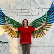 Anita Griebl steht vor großen, ausgebreiteten Flügeln – ein Symbol für Freiheit, Wachstum und persönliche Transformation im Herzens-Rückblick 2025.