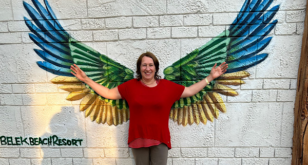 Anita Griebl steht vor großen, ausgebreiteten Flügeln – ein Symbol für Freiheit, Wachstum und persönliche Transformation im Herzens-Rückblick 2025.