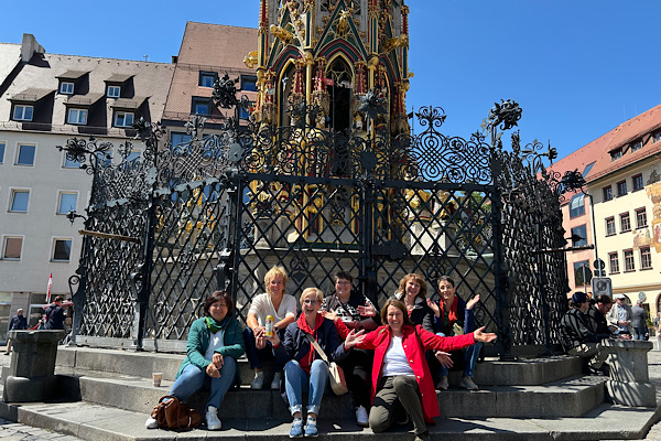 Sieben Dienstagsfrauen beim gemeinsamen Ausflug nach Nürnberg, zusammen vor einem Brunnen platziert.