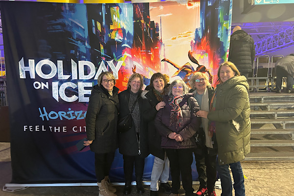 Sieben Freundinnen vor dem Holiday‑on‑Ice‑Plakat in München – ein besonderer Moment unseres gemeinsamen Ausflugs im Januar 2025.
