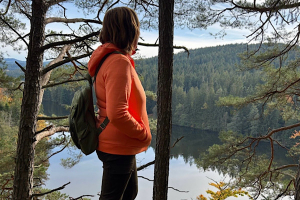 Jahresrückblick Anita steht im Wald und schaut in die Ferne – Symbol für Rückblick und Weitblick.