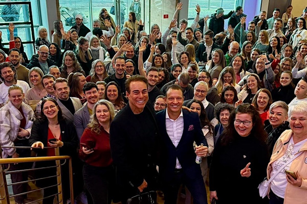 Gruppenfoto vor einer Treppe mit Simon Bowler und Jeff Roberti im Vordergrund.