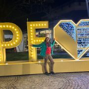 Anita Griebl steht abends in Pforzheim vor leuchtenden PF‑Buchstaben und einem Herz und öffnet die Arme weit.