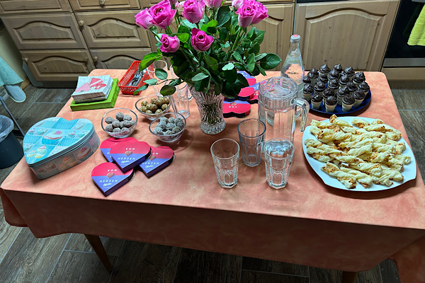 Ein liebevoll gedeckter Tisch mit Snacks, Blumen und Herzpralinen beim Treffpunkt Lebensfreude.