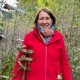 Anita Griebl geht lächelnd durch den Wald und blickt in die Kamera.