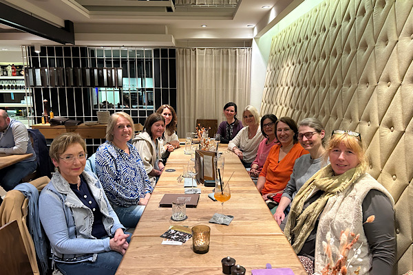 Zehn bewusste Unternehmerinnen sitzen gemeinsam im Lokal – ein Abend voller Austausch, Lachen und Verbundenheit.