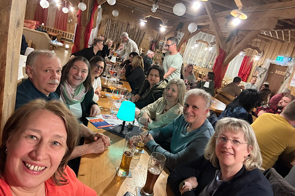 Ein fröhliches Selfie unseres kleinen Fanclubs – Freundinnen und Partner sitzen gemeinsam auf dem Tisch und feiern Michaela Hafners Bühnenabend.