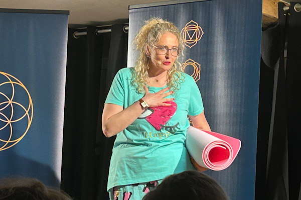 Michaela Hafner auf der Bühne, dem Publikum zugewandt, mit der Hand vor ihrem Herzen.