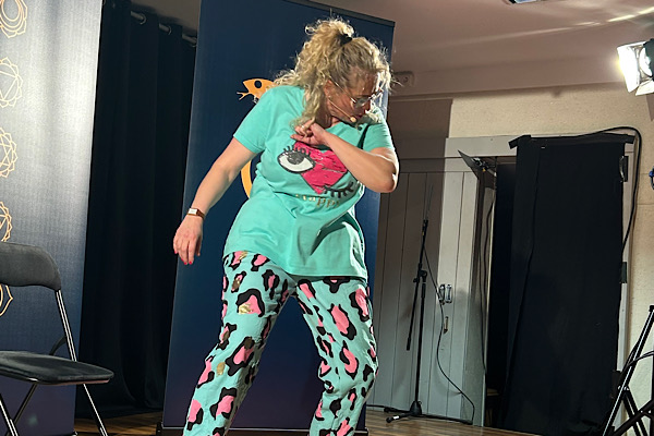 Michaela Hafner steht auf der Bühne, schaut nach unten und macht eine wegwerfende Handbewegung.