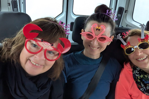 Drei Frauen aus unserem Team posieren mit lustigen Brillen und genießen den Moment voller guter Laune.