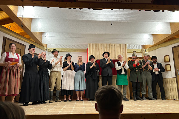 Ensemble des Theaterstücks ‚Der Rauberpfaff‘ steht gemeinsam auf der Bühne für das Abschlussfoto.