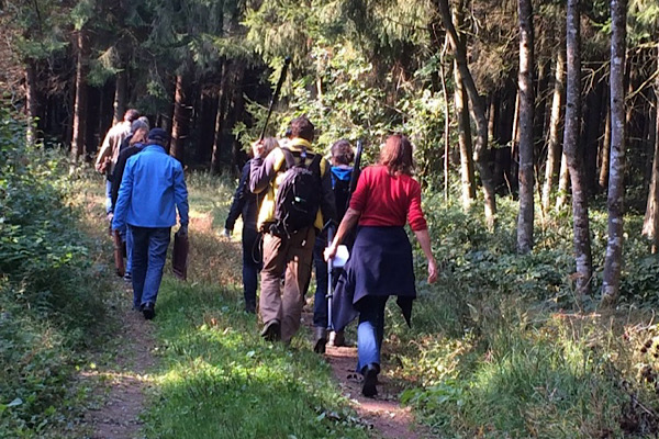 Teilnehmer und Filmteam gehen gemeinsam einen Waldweg entlang. Wut-Pfad Erfahrungen aus dem BR‑Dreh zum Wut‑Pfad.