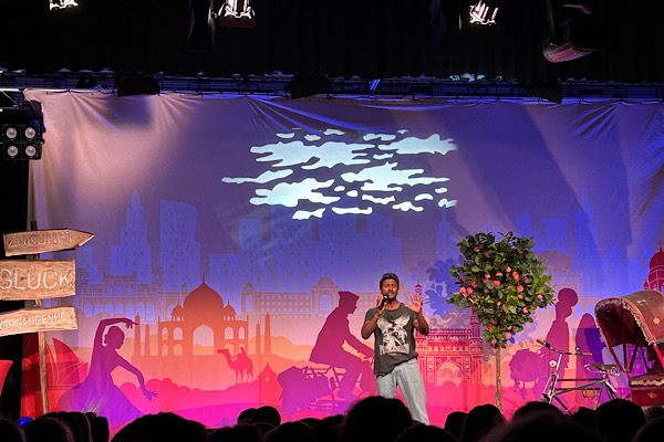 Biyon Kattilathu auf der Bühne während seiner Live‑Show ‚Eine Reise zum Glück‘.