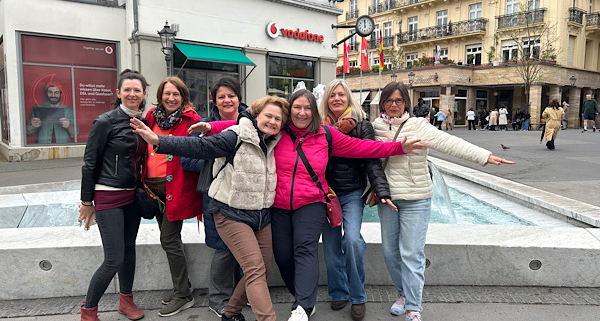 Unser Team posiert fröhlich vor dem Brunnen in der Innenstadt von Baden‑Baden.