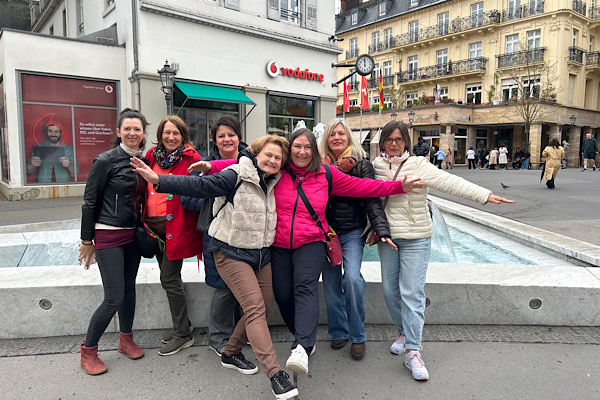 Unser Team posiert fröhlich vor dem Brunnen in der Innenstadt von Baden‑Baden.