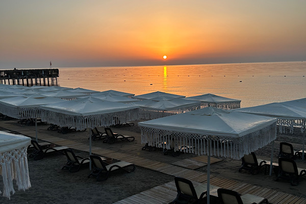 Sonnenaufgang über einem stillen Meer mit weichem Licht am Horizont – Symbol für Tiefe, Wandlung und den Beginn innerer Klärung.