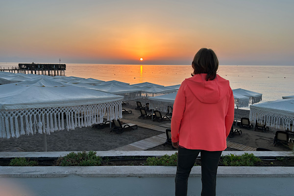Anita am Sonnenaufgang über dem Meer mit warmem, goldenen Licht, das den Horizont erhellt – Symbol für Neubeginn, Klarheit und innere Ausrichtung.