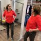 Anita Griebl steht vor einem Spiegel, von vorne und von der Seite sichtbar, im roten Shirt, nachdenklich und nicht in die Kamera blickend.