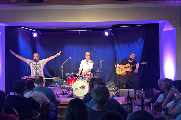 Die drei Musiker von d’BavaResi auf der Bühne: Sebastian Horn und Mathias Kellner mit Gitarren, Otto Schellinger an Schlagzeug und Keyboard.