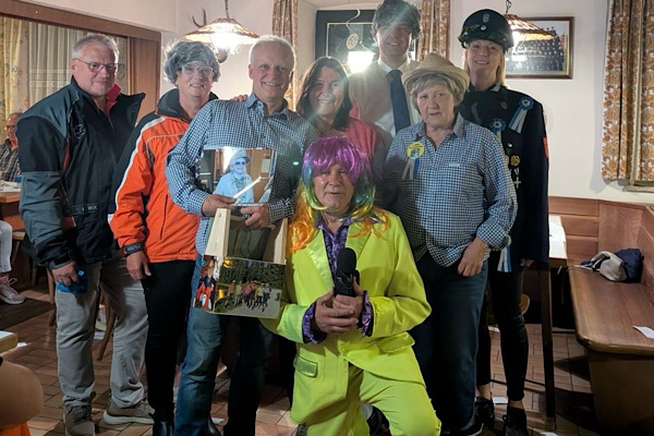 Verkleidete Faschingsgruppe mit Franz und Heidi beim Feiern von Franz’ 60. Geburtstag – fröhliche Stimmung im Lokal.