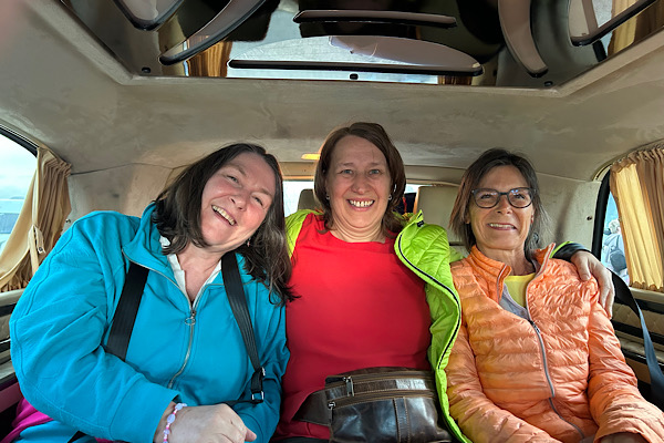 Heidi, Claudia und ich sitzen im luxuriös ausgestatteten Transferbus und lächeln in die Kamera.