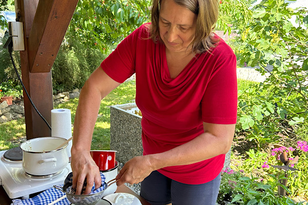 Anita Griebl füllt eine selbst hergestellte Kräutersalbe ab – intuitive Pflanzenarbeit im Kräuter-Energie-Seminar.