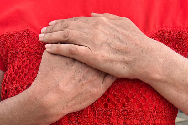 Anita Griebl hält ihre Hände vor der Brust, bekleidet mit einem roten T‑Shirt. Symbolbild für Anfängerfehler in der Persönlichkeitsstärkung – innere Klarheit finden