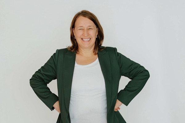 Wendepunkt Selbstständigkeit 2016. Portrait von Anita Griebl, die mit in die Hüften gestützten Händen strahlend in die Kamera lächelt – ein Ausdruck von Freude, Kraft und gelebter Selbstständigkeit.