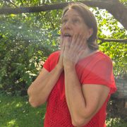 Anita Griebl steht in der Natur, ein Lichtstrahl berührt ihr Gesicht, sie blickt nach oben – Symbol für Herzöffnung und energetische Bewusstwerdung.