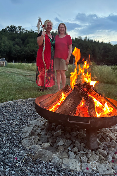 Kraftvolles Feuer in der Feuerschale bei Anitas Feuerritual; im Hintergrund Anita Agnes Aumer und Anita Griebl.