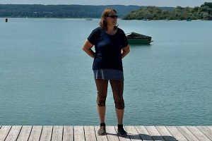 Ich bin nicht in meiner Mitte Anita steht auf einem Holzsteg am Ammersee und blickt seitlich über das Wasser; ruhige, natürliche Stimmung.