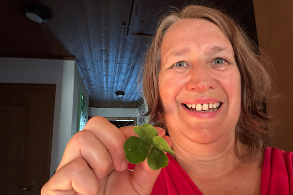 Monatsrückblick Juni 2026 – Anita Griebl hält das neunte vierblättrige Kleeblatt und lächelt.